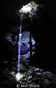 A single beam of light in the darkness of Dos Ojos cenote... by Nick Blake 